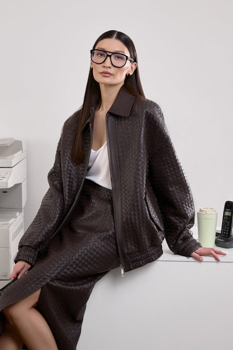 A woman wearing a relaxed-fit brown bomber jacket with two side pockets, featuring a softly structured silhouette that blends everyday ease with modern style.
