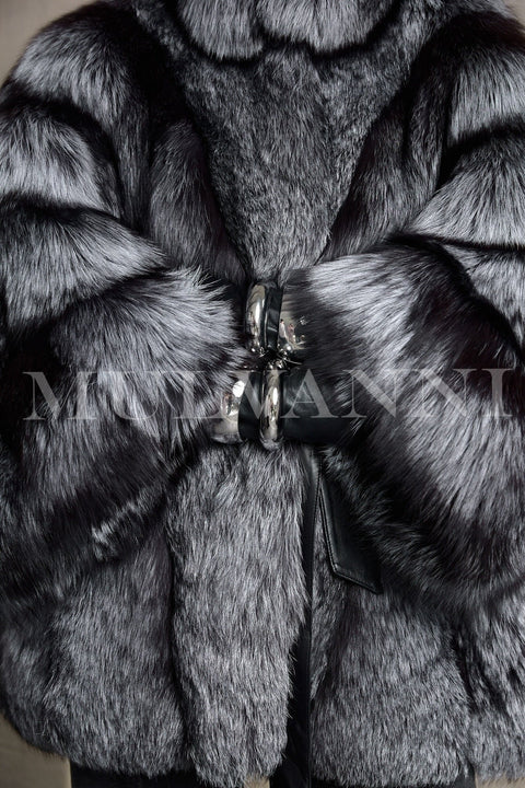 A graceful woman walks in a stunning silver fox fur coat with flowing fur and a defined waist, radiating upscale winter glamour.