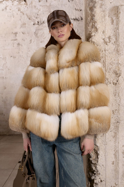 A woman wears a luxurious Gold Fox Fur Coat paired with jeans, showcasing a striking blend of fiery natural hues and casual elegance.